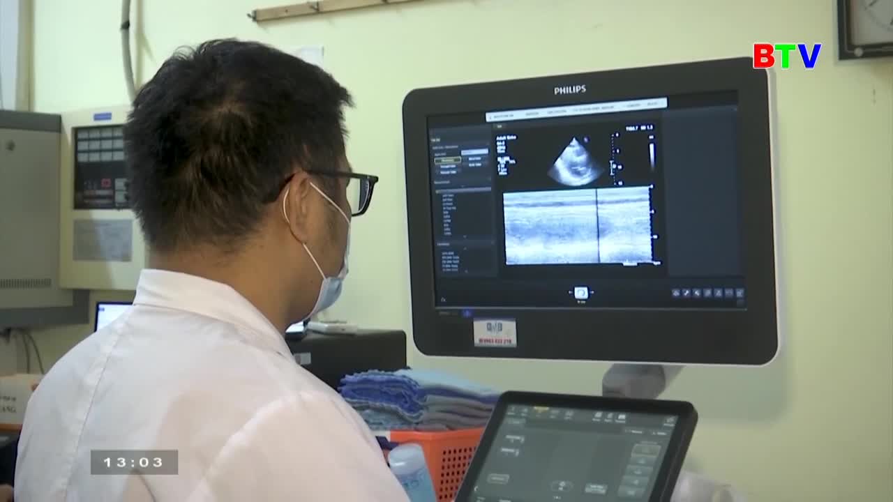 A doctor in a white coat studies a Philips monitor displaying a medical scan, likely an ultrasound. The BTV logo is visible, suggesting this is part of a report from Bac Ninh TV in Vietnam.

