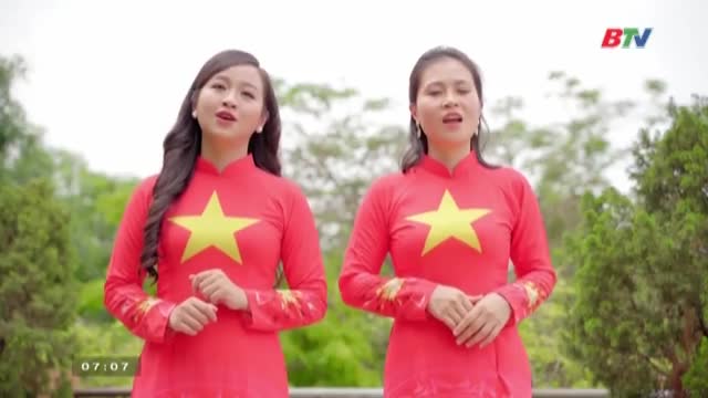 Two women in matching red áo dài, each with a yellow star, stand side-by-side, their mouths open as they sing. The scene is likely from a Bac Ninh TV broadcast, with the BTV logo visible in the top right corner.
