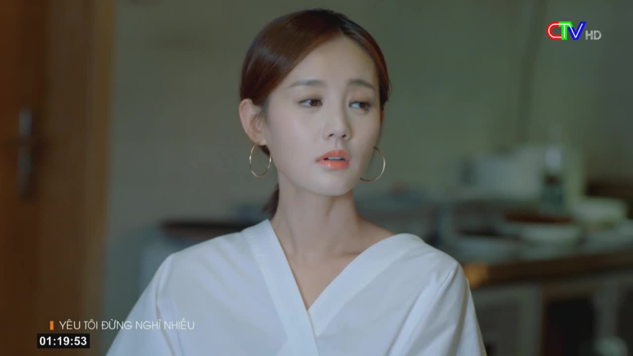 The woman in the white top looks thoughtful, her gaze slightly off-camera. A Ca Mau TV logo sits in the corner, and the timecode indicates the scene is from a show called "I Love You, Don't Think Too Much."
