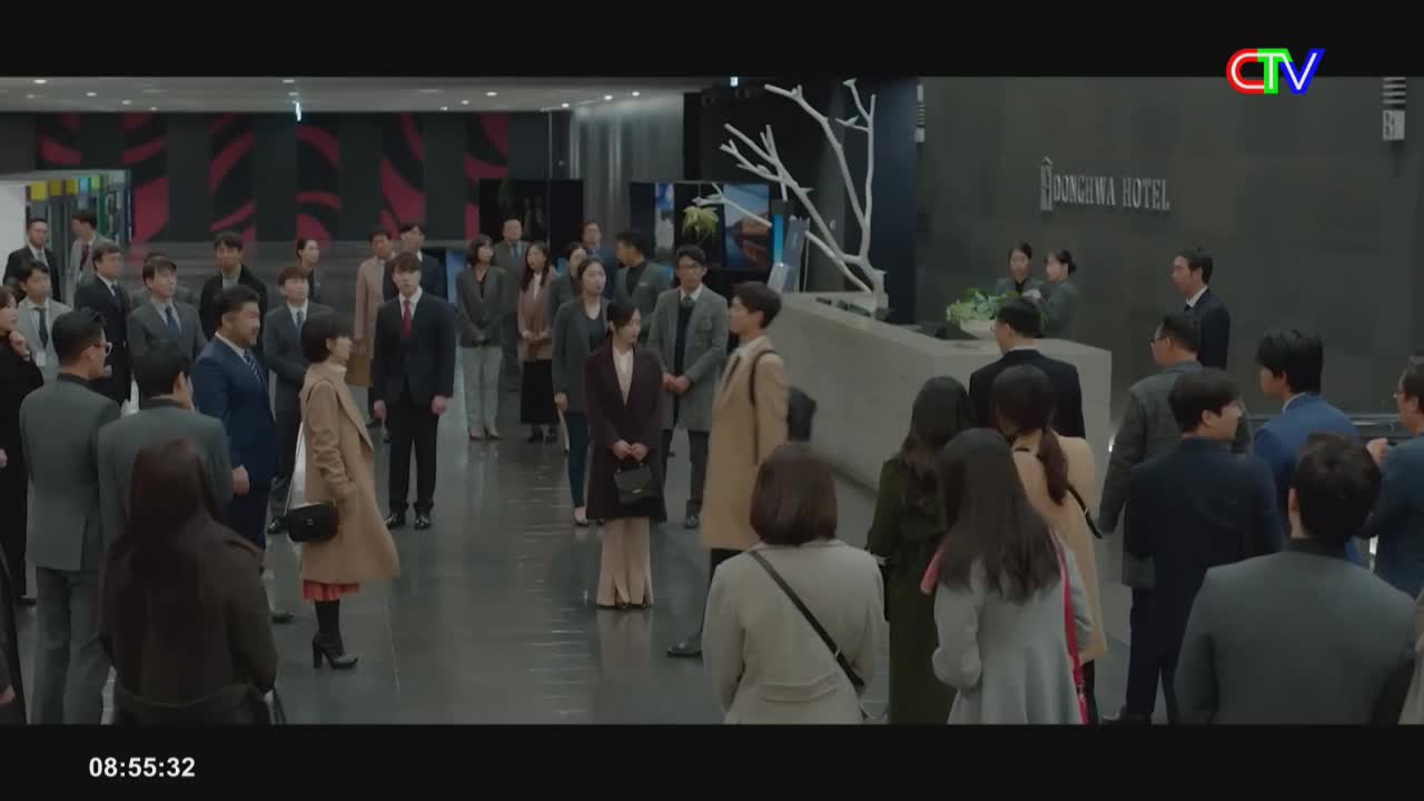 A crowd of people in suits and dresses are gathered in a hotel lobby. A woman in a tan coat stands out, facing away from the camera, as a CTV logo appears in the upper right corner.