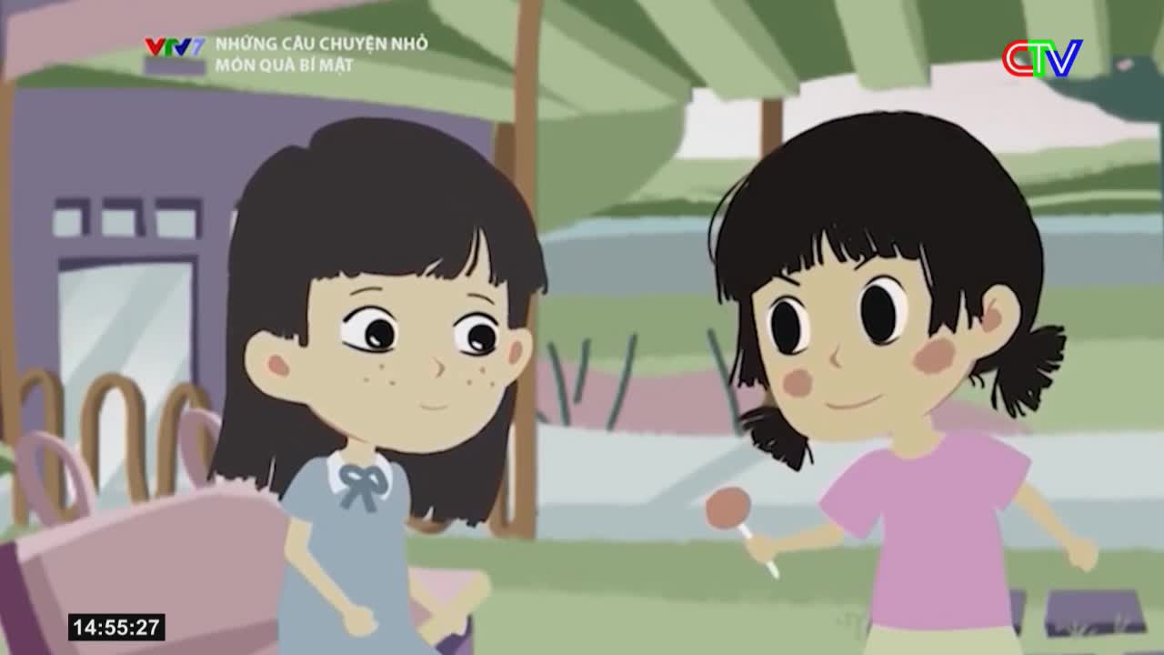 A girl in a pink shirt offers a lollipop to another girl in a blue dress. The scene unfolds outdoors, with a hint of the Ca Mau TV logo in the corner.