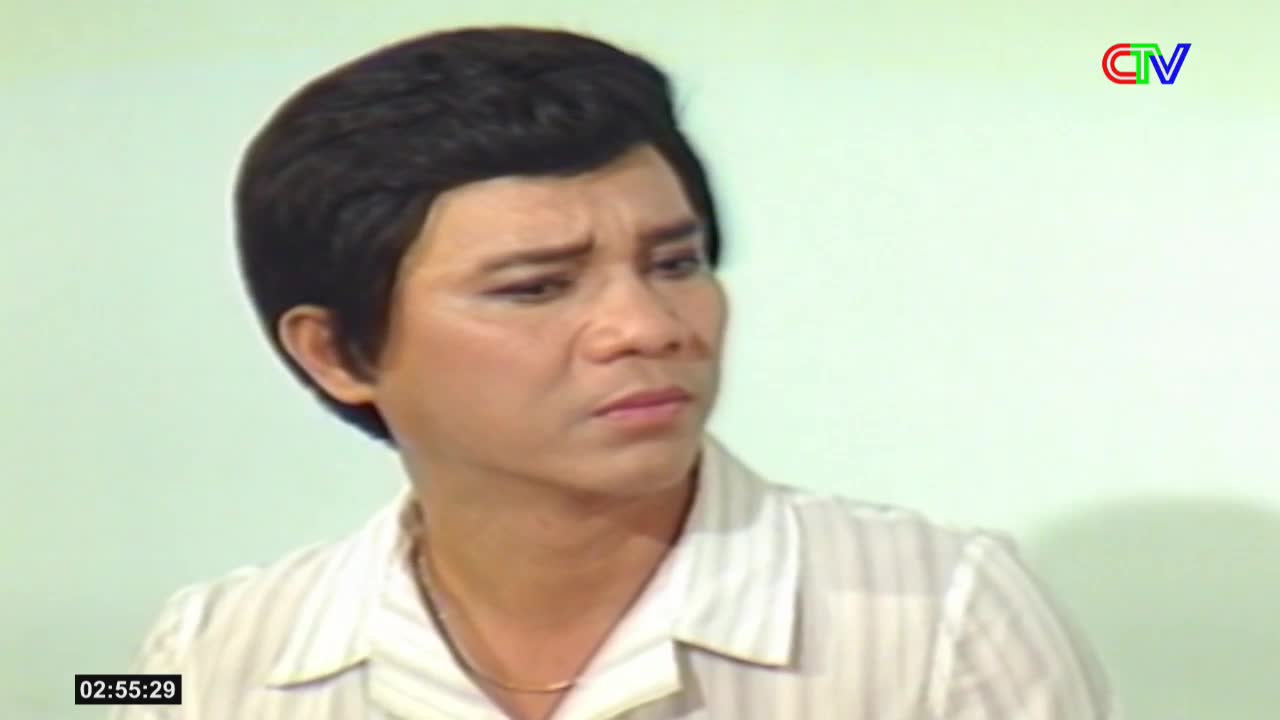A man with dark, styled hair and a striped shirt looks off to the side with a concerned expression. The Ca Mau TV logo appears in the upper right corner.