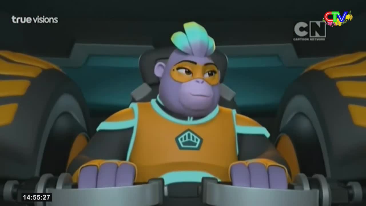 A purple gorilla in a bright orange and teal suit sits in a cockpit, her hands resting on the controls. The large, dark tires of her vehicle loom on either side.