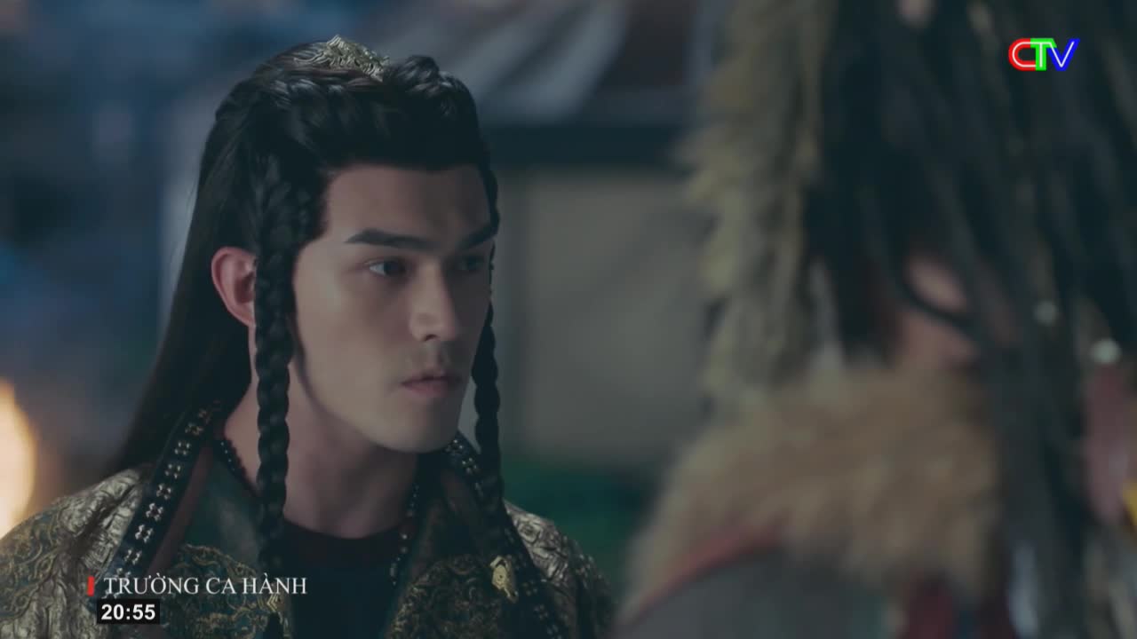 A man with dark, braided hair and an ornate, patterned robe turns his head, his gaze fixed on someone just out of frame. The Ca Mau TV logo appears in the corner of the screen, indicating this scene is from a broadcast in Vietnam.