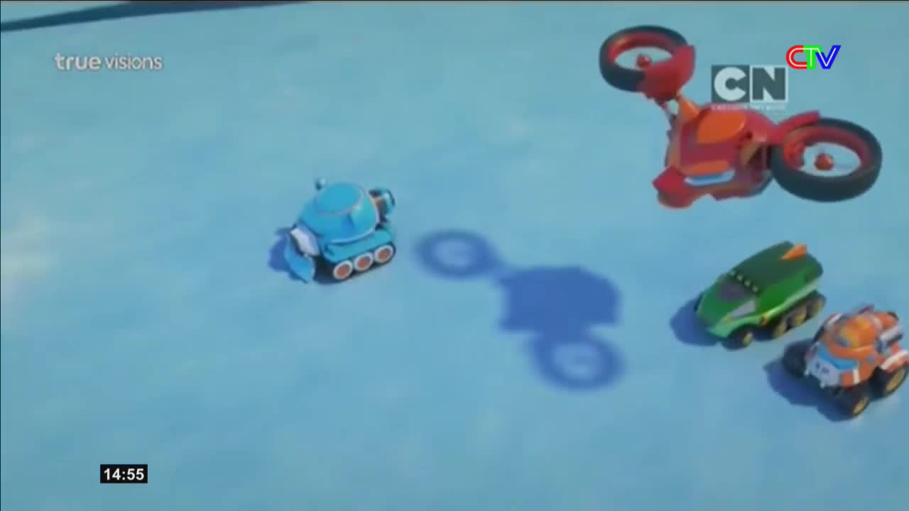 A bright blue toy vehicle with treads rolls across the blue surface. Above it, a red drone with spinning rotors hovers, casting a long shadow.