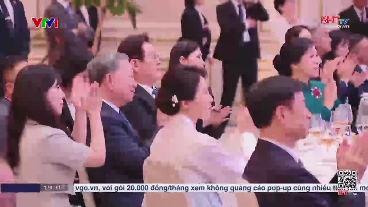People at a formal event are clapping, their hands moving in unison. The scene is broadcast on Ha Tinh TV, with the VTV logo in the corner.
