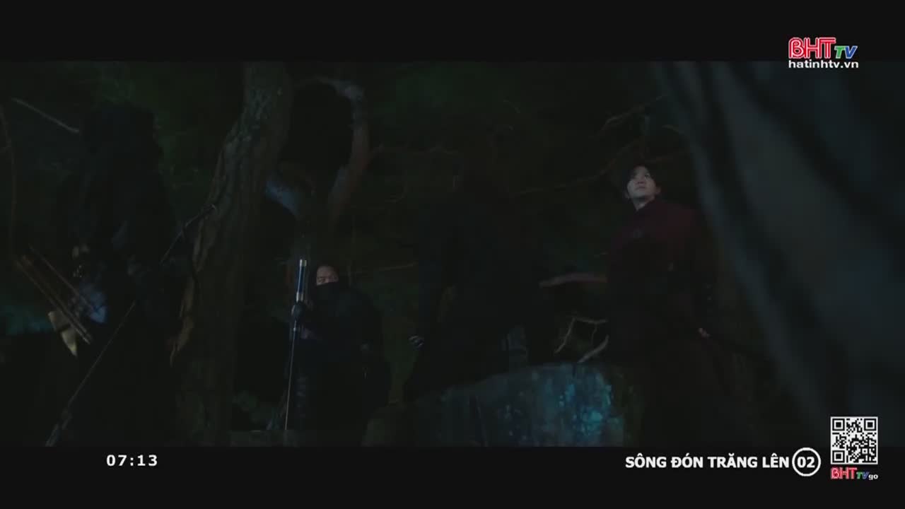 Figures in dark clothing are positioned near trees, one holding a long pole. A man in a maroon shirt looks up, as if listening to something.

