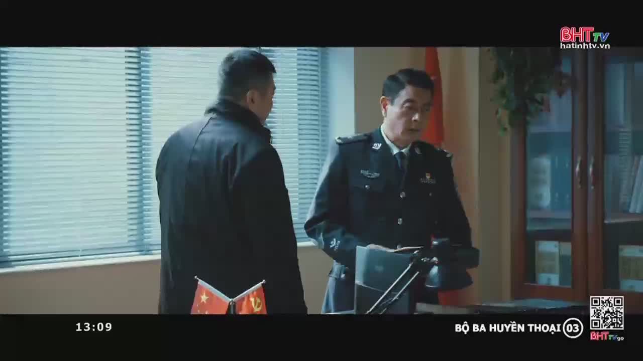 The man in uniform, standing behind a desk, gestures with his hands as he speaks to the other man. The scene is broadcast on Ha Tinh TV in Vietnam.
The man in uniform, standing behind a desk, gestures with his hands as he speaks to the other man. The scene is broadcast on Ha Tinh TV in Vietnam.