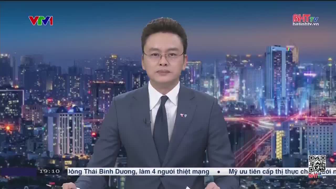 A man in a suit, wearing glasses, is speaking directly to the camera, against a backdrop of a city skyline. The logo for Ha Tinh TV is visible in the corner, and the time is displayed at the bottom of the screen.
A man in a suit, wearing glasses, is speaking directly to the camera, against a backdrop of a city skyline. The logo for Ha Tinh TV is visible in the corner, and the time is displayed at the bottom of the screen.