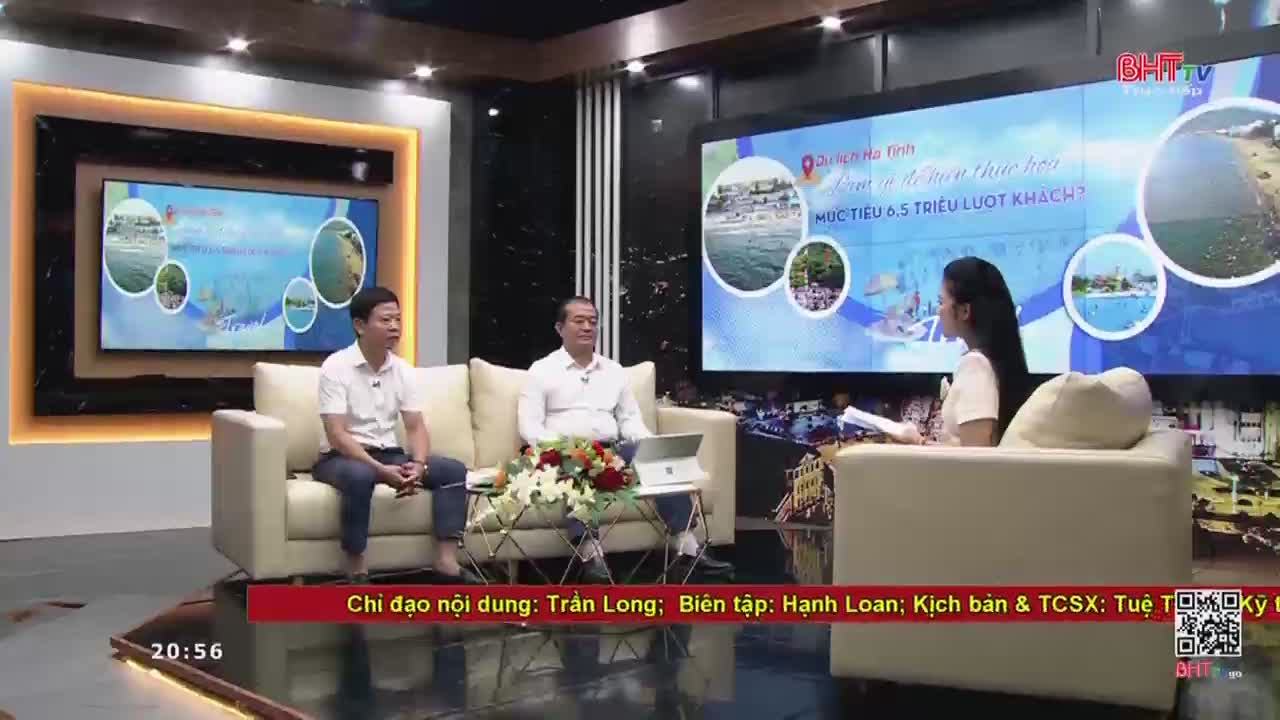 Two men sit on a couch in a television studio, facing a woman who is seated on another couch. A large screen behind them displays images of coastal scenery and text in Vietnamese.