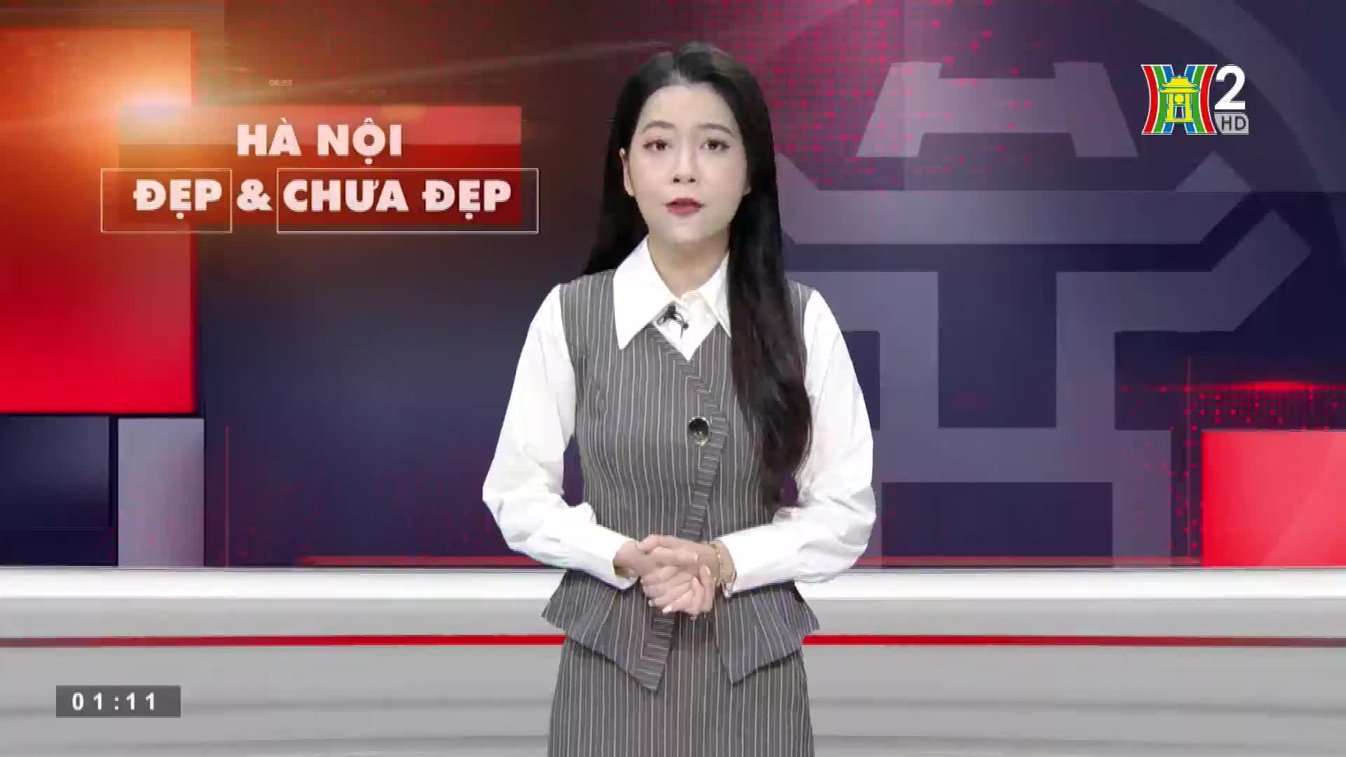 A woman in a striped vest and skirt stands in front of a backdrop, speaking directly to the camera. The HanoiTV2 logo is visible in the corner, and the title "Hà Nội ĐẸP & CHƯA ĐẸP" is displayed above her.

