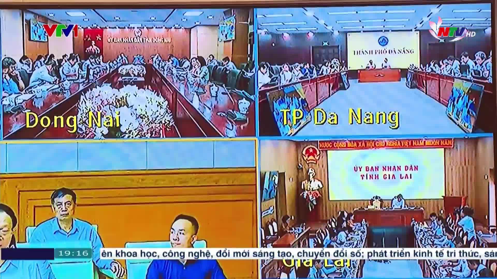 Four separate meeting rooms are displayed on the screen, each with rows of people seated at long tables. The screen shows a broadcast from Vietnam television, with the time displayed in the corner.
