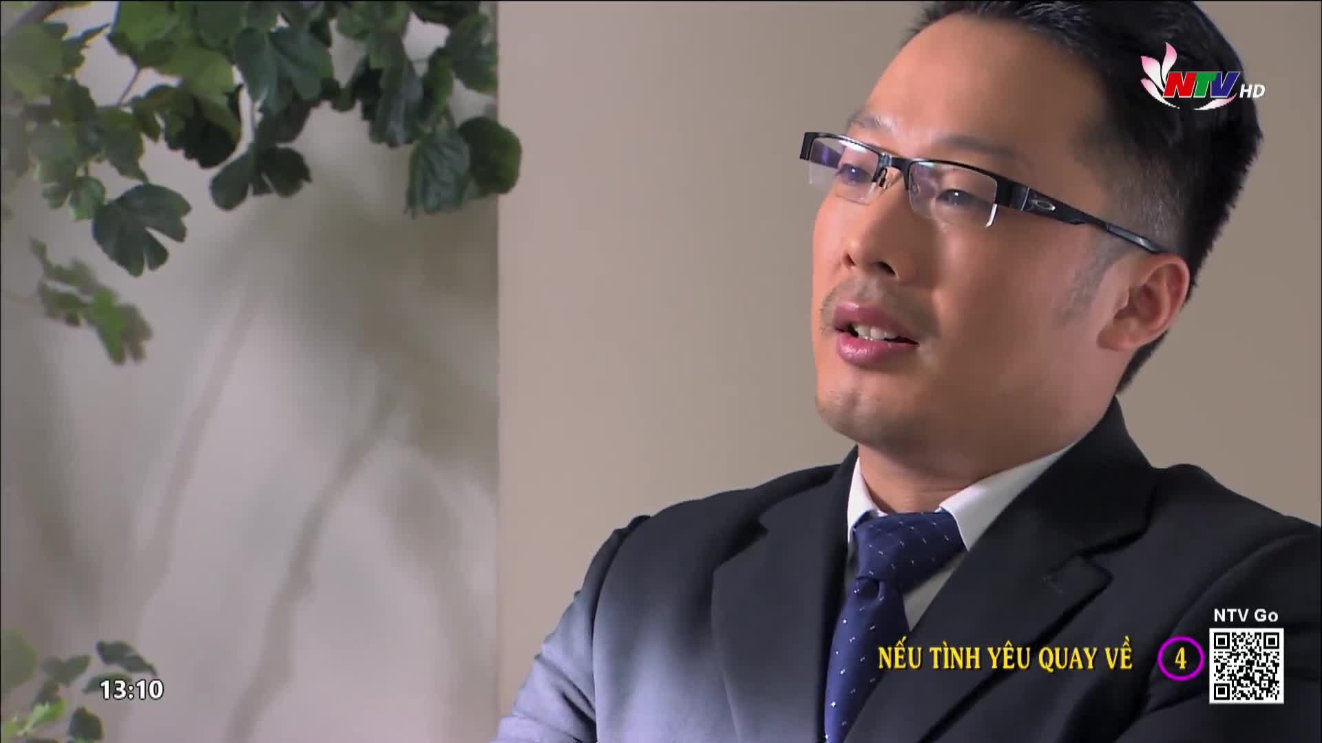 A man in a suit, wearing glasses, is speaking, his mouth slightly open. The Nghe An TV logo is visible in the corner, and the show's title, "Nếu Tình Yêu Quay Về," is displayed on the screen.
