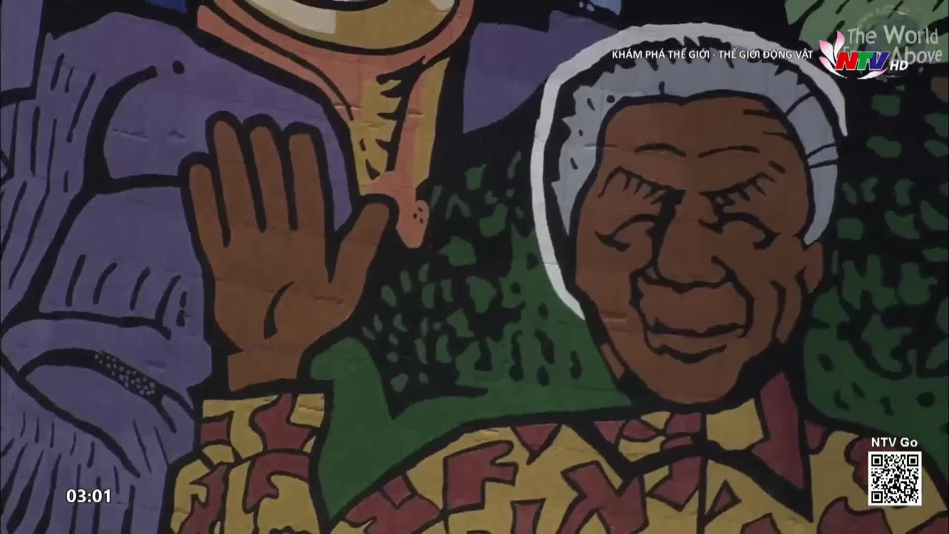 A mural depicts a man with closed eyes, his hand raised in greeting. This artwork, broadcast by Nghe An TV, is part of a larger scene in Vietnam.