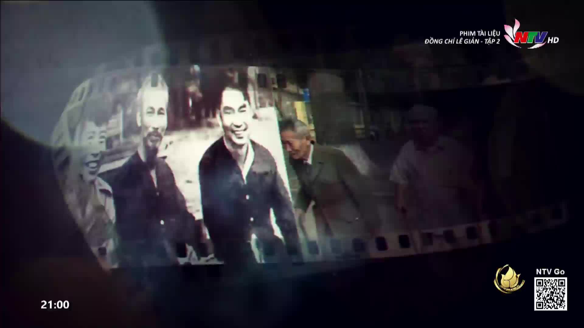 A film strip plays, showing a group of men smiling in black and white. The Nghe An TV logo appears on screen, indicating this is part of a documentary.
