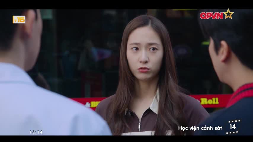 A woman stares intently, her expression a mix of concern and slight annoyance. Two men flank her, their faces partially obscured, as they seem to be in a tense conversation.
