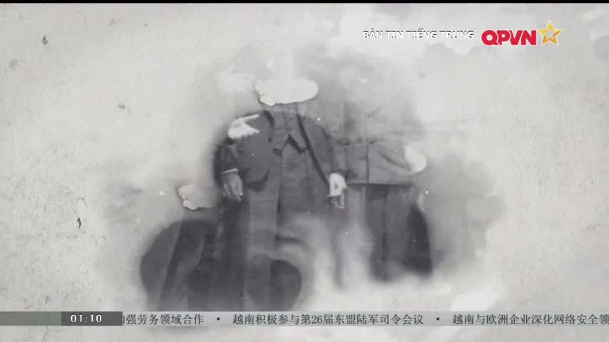 Two men, blurred and faded, stand close together, their forms barely visible against the aged background. The QPVN logo and Chinese text at the top and bottom suggest this is a news broadcast from Vietnam.
Two men, blurred and faded, stand close together, their forms barely visible against the aged background. The QPVN logo and Chinese text at the top and bottom suggest this is a news broadcast from Vietnam.