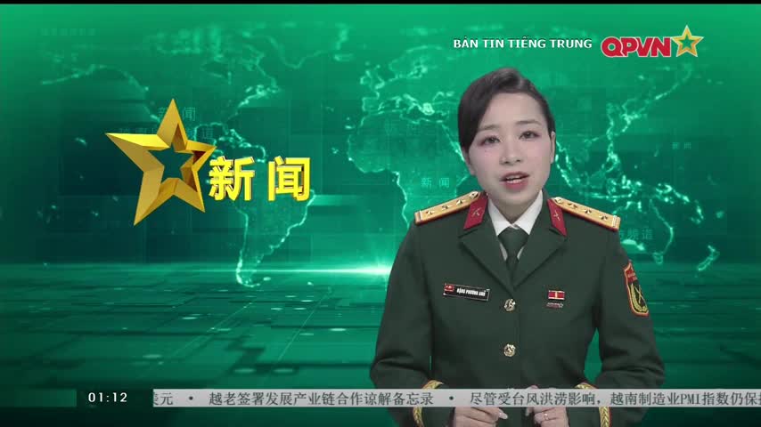 A woman in a military uniform speaks, her face framed by a green backdrop with a world map. The logo for QPVN and the word "news" in Chinese characters are visible on the screen.
A woman in a military uniform speaks, her face framed by a green backdrop with a world map. The logo for QPVN and the word "news" in Chinese characters are visible on the screen.