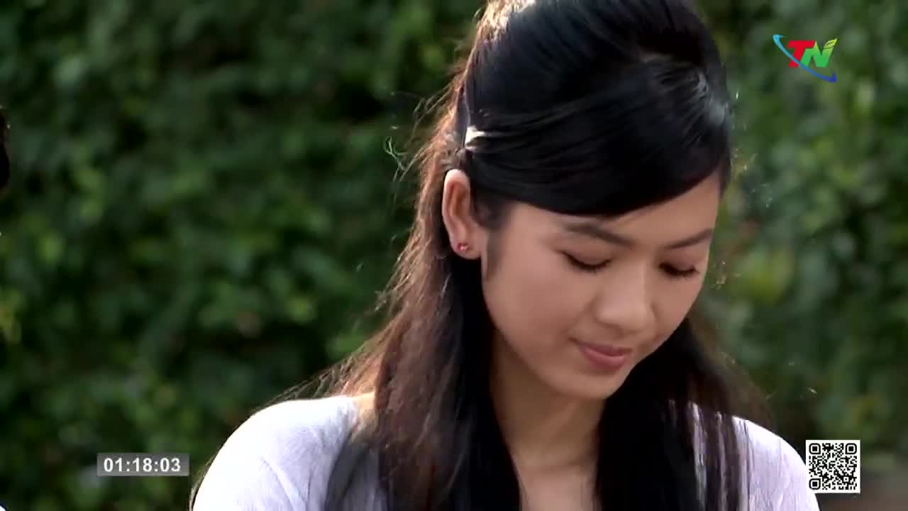 A young woman with dark hair is looking down, her expression soft. The Thai Nguyen TV logo is visible in the corner, and the timecode reads 01:18:03.
