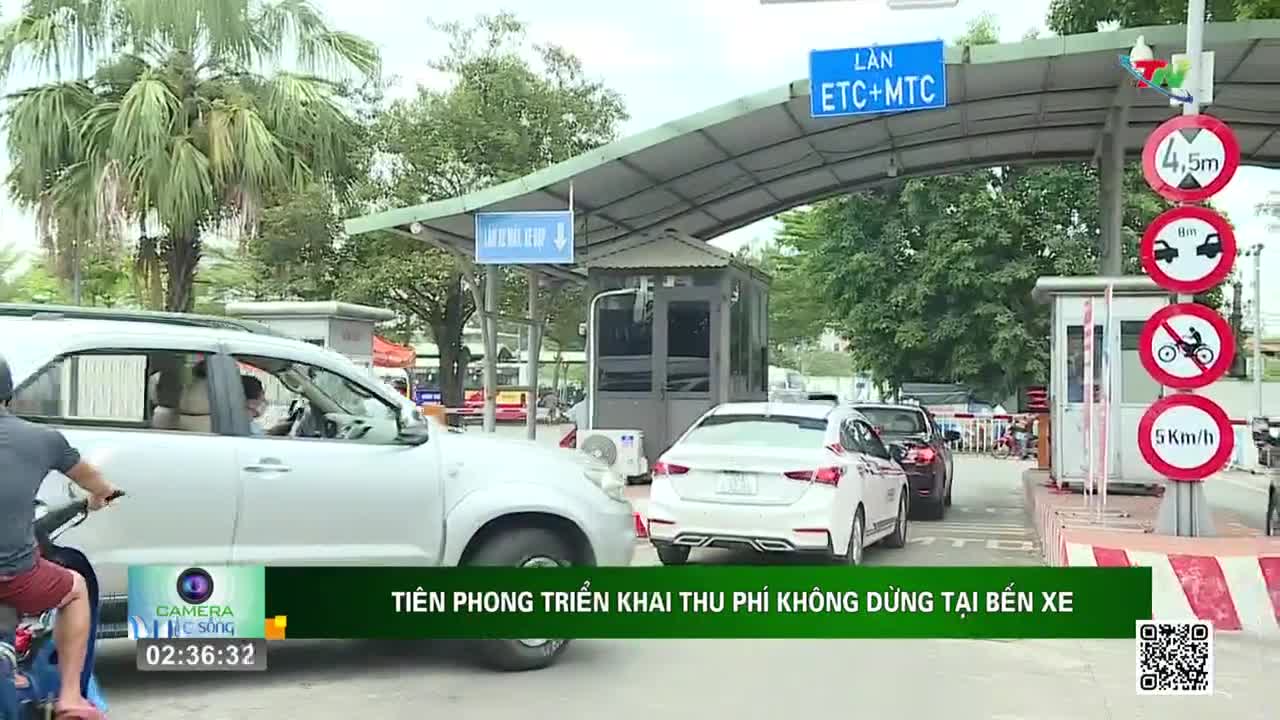 Cars are inching forward, approaching a toll booth with signs in Vietnamese. A motorcycle rider is visible on the left, next to a white SUV, as the Thai Nguyen TV broadcast rolls.

