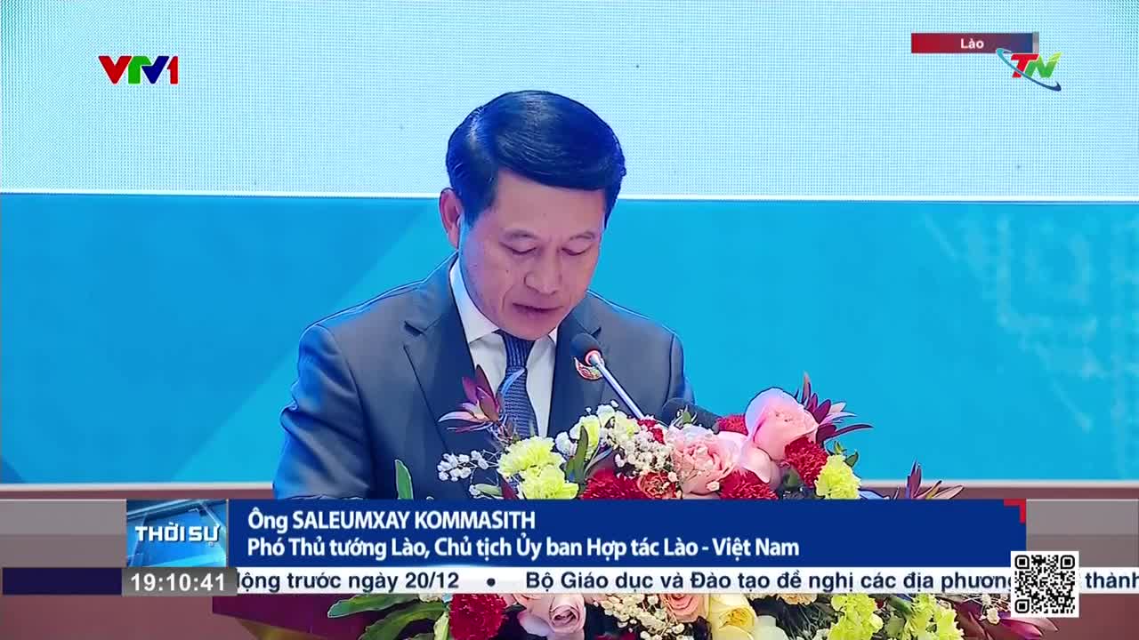 A man in a suit reads from a paper at a podium, the Thai Nguyen TV logo visible in the corner. Below him, text identifies him as a Lao official, with information about the event displayed at the bottom of the screen.
A man in a suit reads from a paper at a podium, the Thai Nguyen TV logo visible in the corner. Below him, text identifies him as a Lao official, with information about the event displayed at the bottom of the screen.