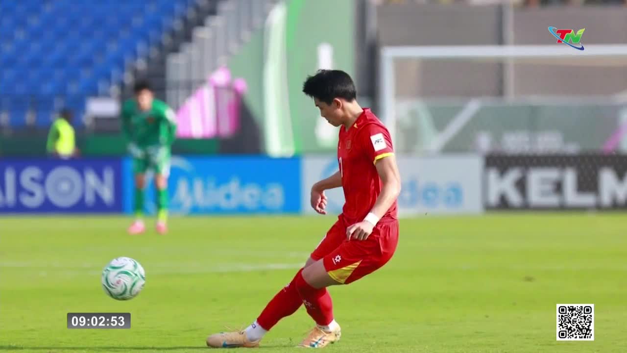 A player in a red jersey is about to kick the ball. The scoreboard shows 09:02:53.