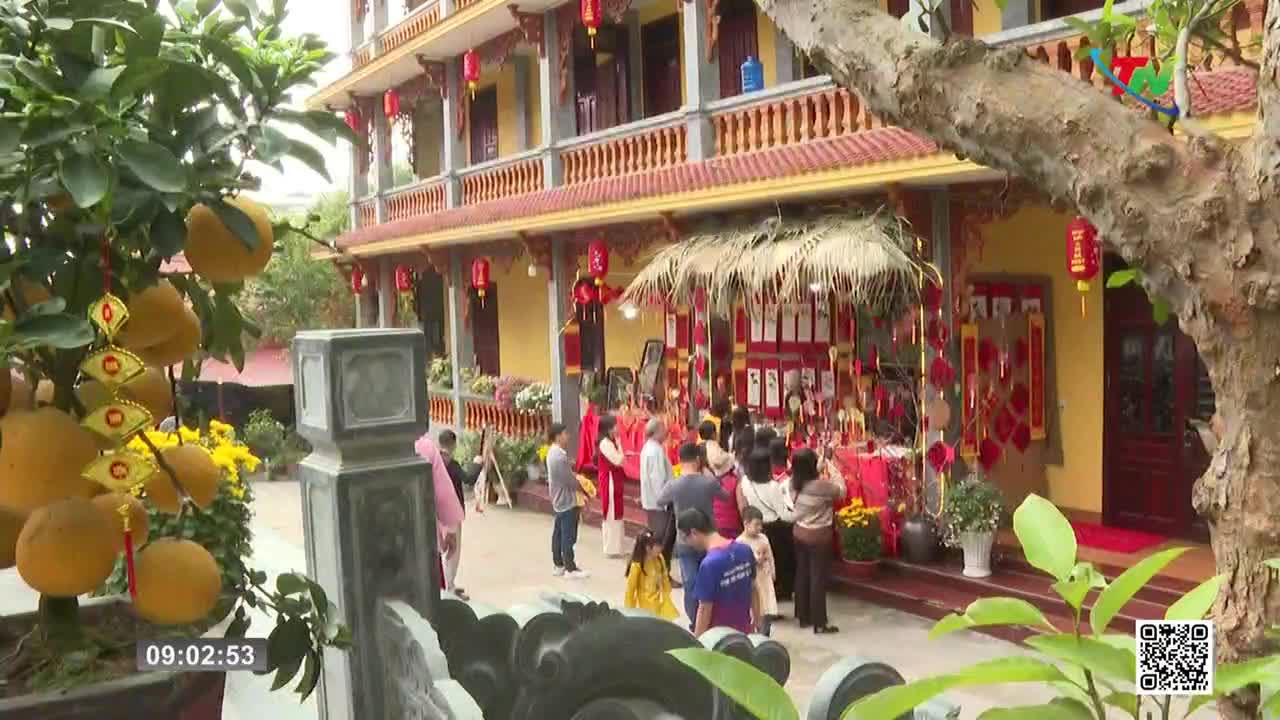 People gather outside a temple, some dressed in red, with offerings laid out on tables. A tree laden with bright yellow fruit stands to the left, decorated with festive ornaments. People gather outside a temple, some dressed in red, with offerings laid out on tables. A tree laden with bright yellow fruit stands to the left, decorated with festive ornaments.