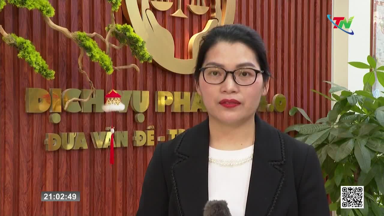 A woman in a black blazer and glasses stands before a wooden wall with gold lettering. The Thai Nguyen TV logo is visible in the upper right corner.