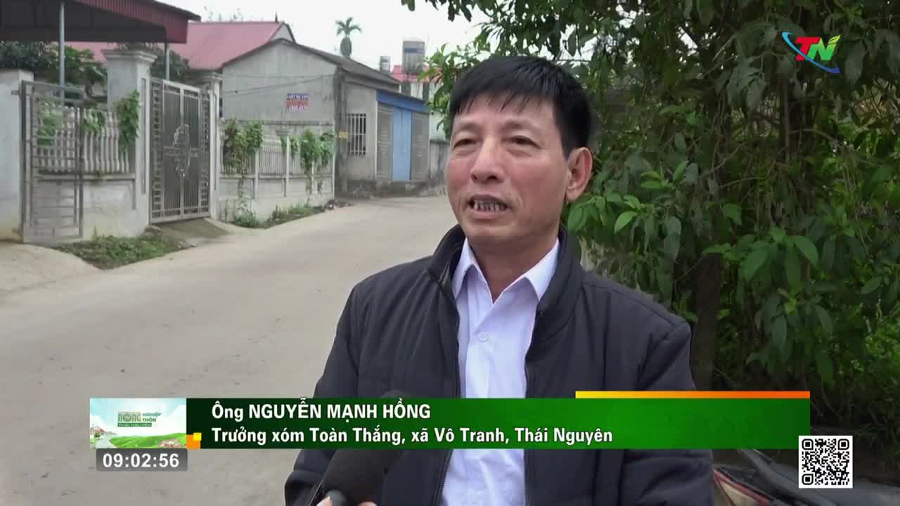 A man stands on a street in Vietnam, speaking into a microphone. A graphic overlay identifies him as Ông Nguyễn Mạnh Hồng, from Toàn Thắng village in Võ Tranh commune, Thái Nguyên province.
