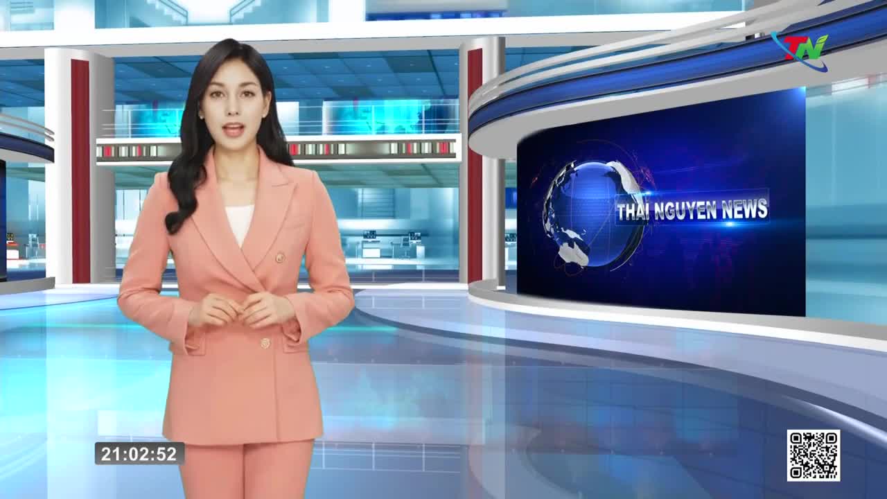 A woman in a peach suit stands in a modern studio, speaking into the camera. Behind her, a screen displays the "Thai Nguyen News" logo with a spinning globe.