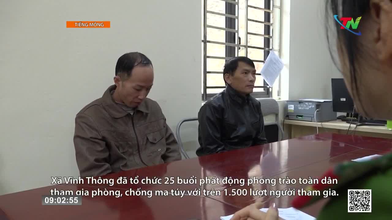 Two men sit at a table, one with his head bowed, the other looking forward. A reporter from Thai Nguyen TV is speaking with them. Two men sit at a table, one with his head bowed, the other looking forward. A reporter from Thai Nguyen TV is speaking with them.