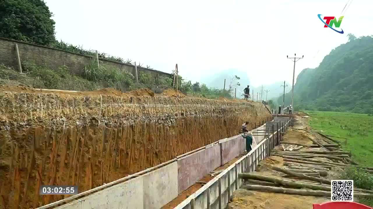 Workers are building a concrete channel beside a deep excavation in the Thai Nguyen countryside. The surrounding hills are lush and green, with a cloudy sky overhead. Workers are building a concrete channel beside a deep excavation in the Thai Nguyen countryside. The surrounding hills are lush and green, with a cloudy sky overhead.