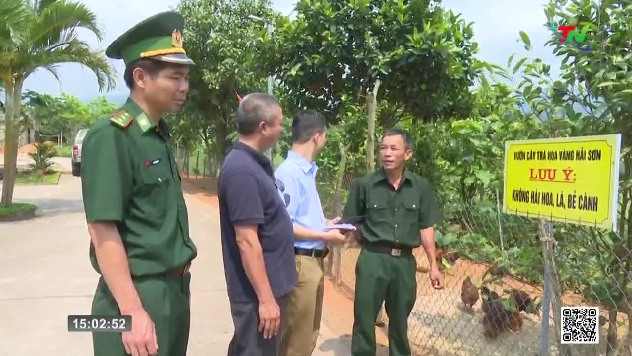 A group of men in military uniforms and civilian clothes stand near a bright yellow sign. Chickens peck at the ground behind a wire fence. The Thai Nguyen TV logo is visible in the upper right corner. A group of men in military uniforms and civilian clothes stand near a bright yellow sign. Chickens peck at the ground behind a wire fence. The Thai Nguyen TV logo is visible in the upper right corner.