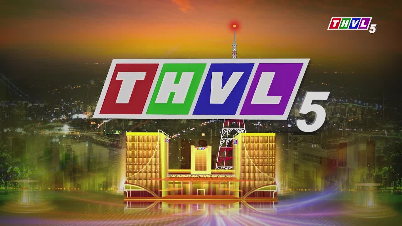 The logo for THVL5, Tra Vinh TV, is front and center, a colorful banner above a stylized building. The background fades into a nighttime cityscape with lights twinkling in the distance.
