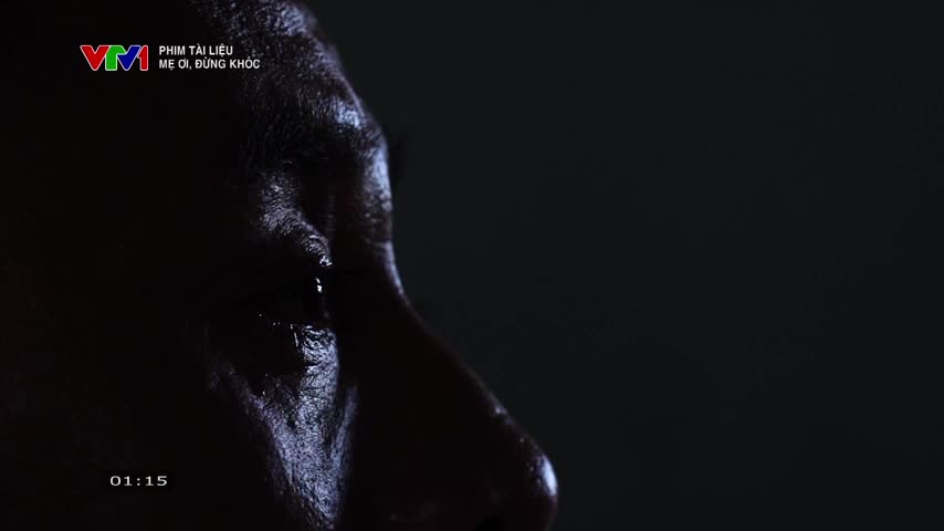Tears glisten on a man's face, illuminated in the dim light. The VTV1 logo and the title of the documentary, "Mother, Don't Cry," are visible in the corner.
