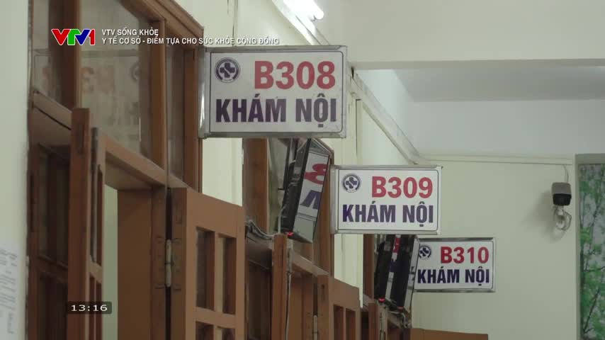 Signs for "Internal Medicine" hang above doorways in a clinic, with the VTV1 logo visible in the corner. The time on the screen reads 13:16, and a security camera watches from the wall.
