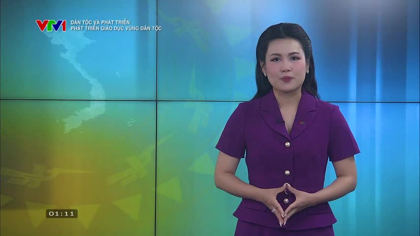 A woman in a purple blazer and skirt stands in front of a screen, her hands clasped in front of her. The VTV1 logo and a map of Vietnam are visible behind her.
