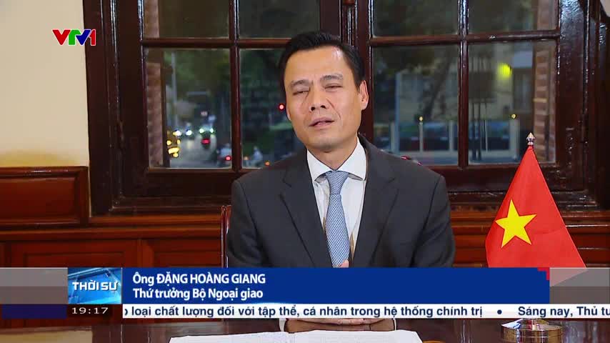 A man in a suit is speaking on VTV1, a Vietnamese news channel. The camera is focused on him, with the Vietnamese flag visible on the right.

